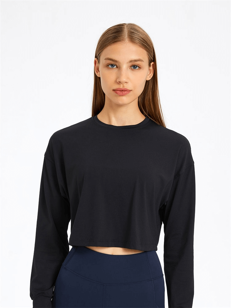 Woman wearing a black spandex sport short sweatshirt with long sleeves, ideal for yoga and activewear fashion.